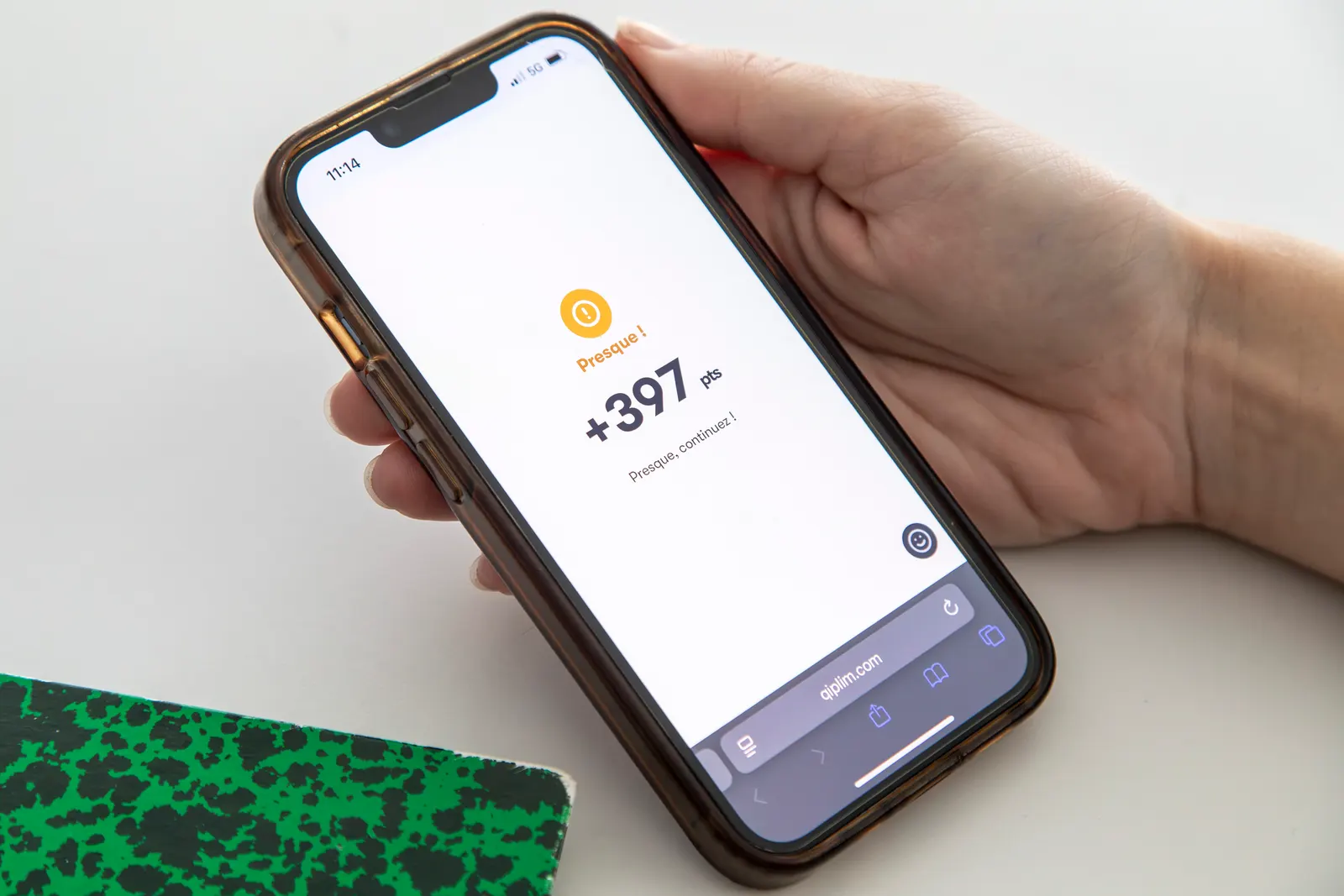 Un téléphone affiche le résultat d’une réponse : « Presque ! », +397 points