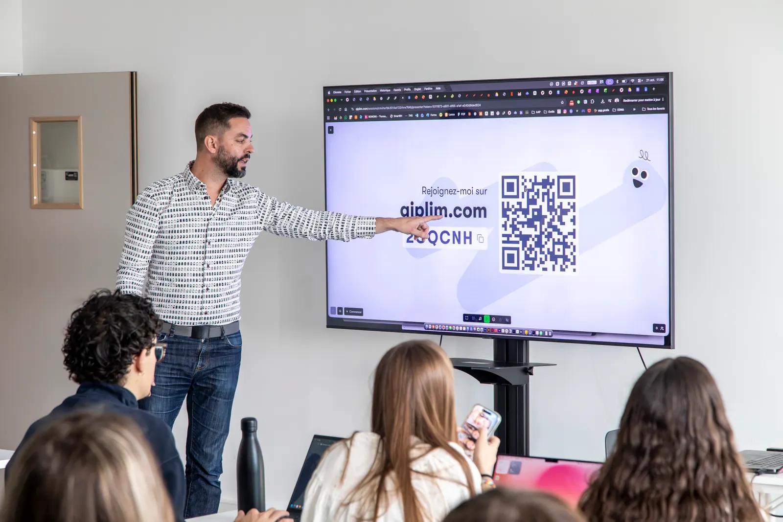 Un enseignant montre à la classe le code et le QR code pour rejoindre l’activité Qiplim