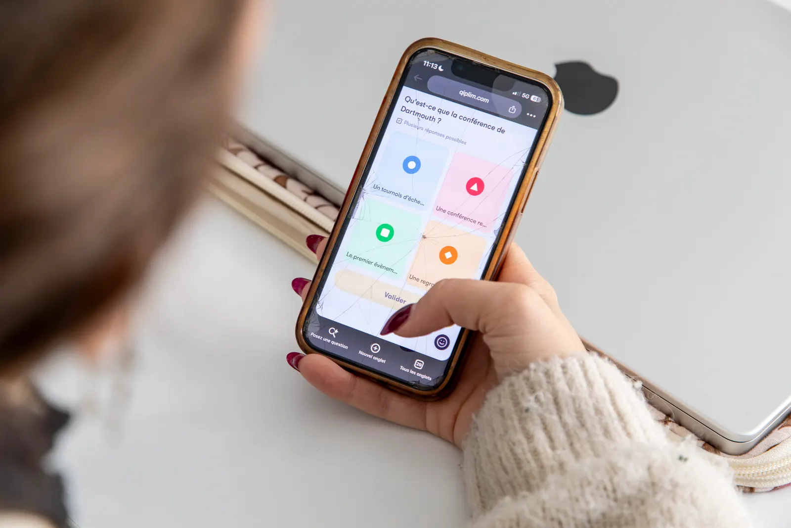 Une étudiante répond à une question de quiz sur son téléphone
